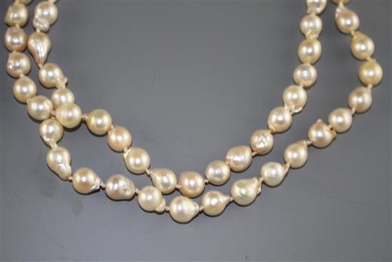 A double strand cultured baroque pearl necklace with yellow metal and garnet ? cluster clasp and one other simulated pearl necklace.